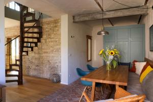 a living room with a wooden table and blue chairs at Idyllic Hideaway In The Countryside in Marienwerder +26 photos