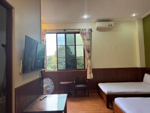 a small room with two beds and a window at ANH DUONg 1 HOTEL in Bảo Lộc