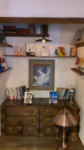 a room with a wooden dresser and books on shelves at Guest House時音 in Joetsu