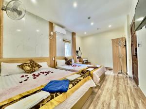 two beds in a hotel room with flowers on them at Văn Phượng Hostel in Cat Ba