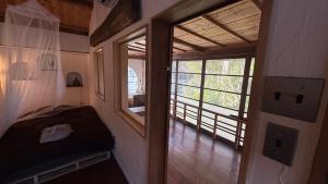 a room with a bed and a door with a window at Guest House時音 in Joetsu