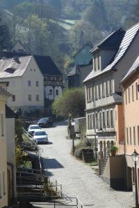 a village with cars parked on a street with buildings at Herberge Landstreicher in Königstein an der Elbe