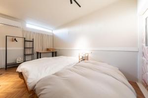 a bedroom with a white bed and a window at Bushido Kashiwa in Kashiwa