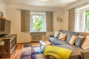 a living room with a couch and a tv at Ferienwohnung Apfelbaum Kitzingen in Kitzingen