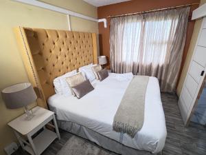 a bedroom with a large bed and a window at Thandi's Guest House in East London
