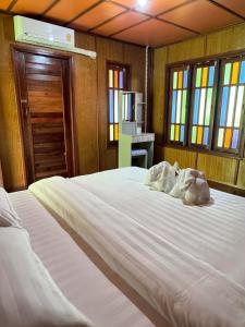 a large white bed in a room with windows at Bangalow Coconut corner in Ban Laem Sai +18 photos