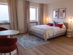 a bedroom with a bed and a table and a window at Berghotel Lindenhof in Siegsdorf +52 photos
