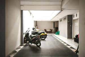 two motorcycles parked in a hallway of a building at INNCA Singa Utara, Semarang in Alastuwo