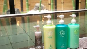 a group of four different colored bottles sitting next to a swimming pool at Hotel Route-Inn Gotenba Eki-Minami in Gotemba