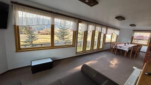 a living room with a table and some windows at Pensiunea Teodora in Dorna Arini