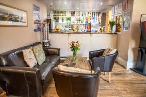 a bar with a leather couch and a table at The Dolphin Hotel in Wincanton
