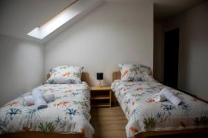 a bedroom with two beds and a skylight at Ízisz Apartman in Mátraterenye