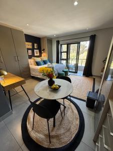 a living room with a bed and a table at The Den Apartements Stellenbosch in Stellenbosch