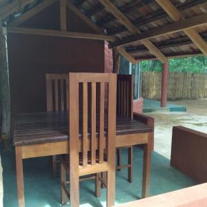 a wooden table and chairs sitting on a patio at Gramatic Cottage Udawalawe in Udawalawe
