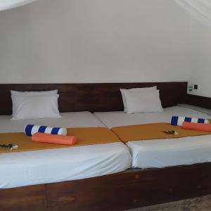 a large bed with two pillows on top of it at Gramatic Cottage Udawalawe in Udawalawe