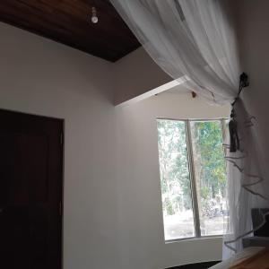 a room with a window and a curtain at Gramatic Cottage Udawalawe in Udawalawe +28 photos
