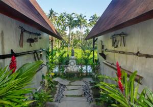 a garden with a stone path in front of a building at Bara Villa by GenuineHost in Tegalalang