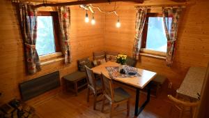 a dining room with a wooden table and chairs at Chata Sauna Sosna in Litmanová +4 photos