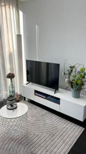 施坦斯Modern apartment Pilatus view self check-in的客厅里有一台白色娱乐中心的电视
