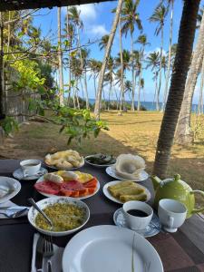 a table with food on it with palm trees and the ocean at Coconut Tree hill Rekawa in Tangalle +76 photos