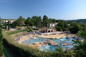 a large swimming pool with people in a resort at Appartement dans résidences de vacances in Salavas