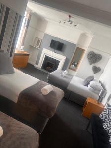 a hotel room with two beds and a fireplace at Sheridans hotel in Wallasey