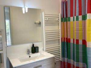 a bathroom with a sink and a shower curtain at Appartement - Hossegor Lac in Hossegor