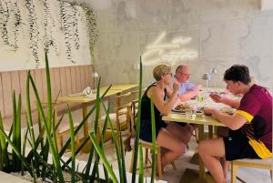 3 persone sedute a un tavolo in un ristorante di La Costa Hotel a Katunayake