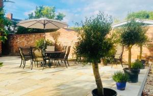 a patio with a table and chairs and an umbrella at Cambridge Villa in Warwick