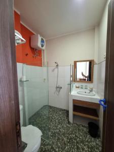 a bathroom with a shower and a sink and a toilet at Bella Vista Premium Homestay in Banyuwangi