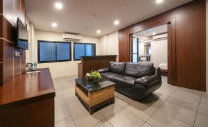 a living room with a leather couch and a table at Gu Hotel Patong in Patong Beach