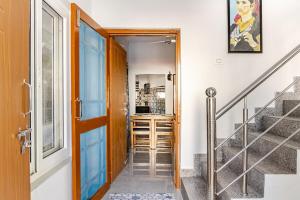 a hallway with a door and a staircase with a stair case at Baidehi Cottage in Rishīkesh