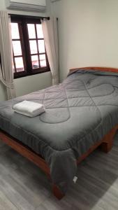 a large bed in a room with two windows at MeeboonHome in San Kamphaeng
