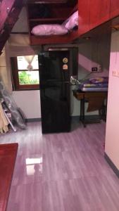 a room with a refrigerator and a table in a room at MeeboonHome in San Kamphaeng