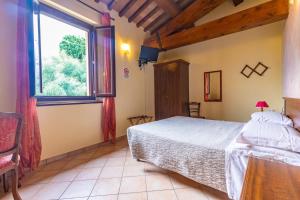a bedroom with a bed and a large window at Agriturismo La Querciola in Riolo Terme