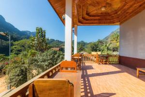 a balcony with wooden chairs and a view of the mountains at Nongkhiaw IngIng Backpackers Hostel in Nongkhiaw
