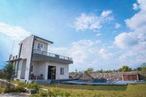 a house with a pool in front of it at Silverleaf Homestay in Borāj