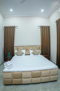 a bedroom with a large bed with brown curtains at Silverleaf Homestay in Borāj