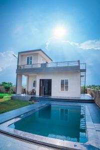 a house with a swimming pool in front of a house at Silverleaf Homestay in Borāj
