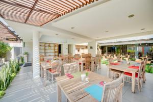 a restaurant with wooden tables and chairs on a patio at Villa Jerami & Spa in Seminyak
