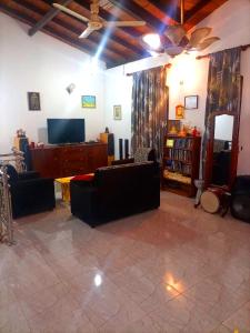 a living room with couches and a flat screen tv at Sylt Haus in Beruwala