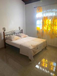 a bedroom with a bed in a room with a window at Sylt Haus in Beruwala