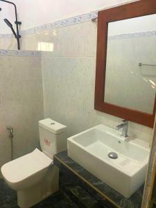 a bathroom with a sink and a toilet and a mirror at Sylt Haus in Beruwala +29 photos