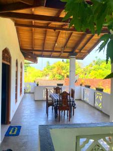 a patio with a table and chairs under a wooden roof at Sylt Haus in Beruwala