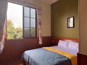 a bedroom with a bed and a window at ANH DUONg 1 HOTEL in Bảo Lộc