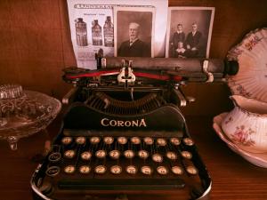 an old typewriter sitting on a table with a picture of a man at Barossa Valley’s Captain Rodda’s Cottage in Angaston