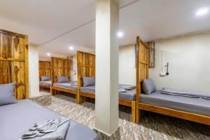 a room with three beds and wooden walls at Nongkhiaw IngIng Backpackers Hostel in Nongkhiaw