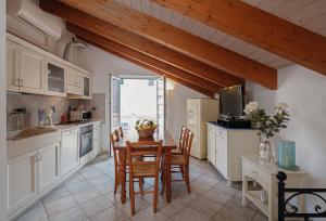a kitchen with a table and chairs and a television at Appartamenti In Piazzetta in Deiva Marina