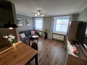 a living room with a blue couch and a table at Apartament Lewin Kłodzki in Lewin Kłodzki