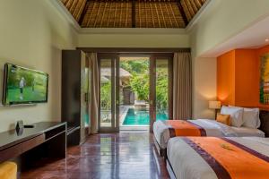 een slaapkamer met 2 bedden en een tv en een zwembad bij Mahagiri Villas Sanur in Sanur
